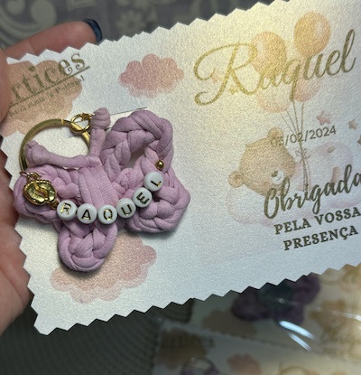 Chaveiro borboleta lilás com nome Raquel sobre cartão de agradecimento branco e dourado