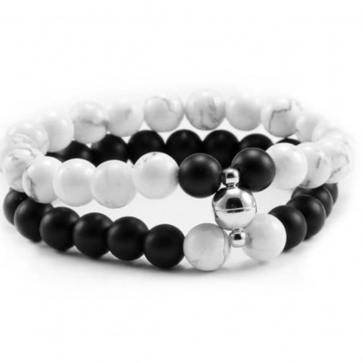 Pulseiras com contas pretas, brancas e prateadas sobre fundo branco