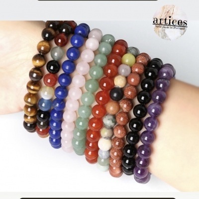 Pulseiras coloridas de contas redondas de pedras semipreciosas num braço