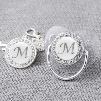 chupeta translúcida com acessório prateado com pedras e letra M