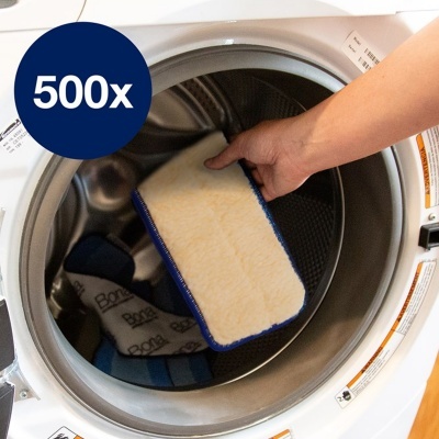 Máquina de lavar roupa aberta com mão a segurar esponja e roupa no interior