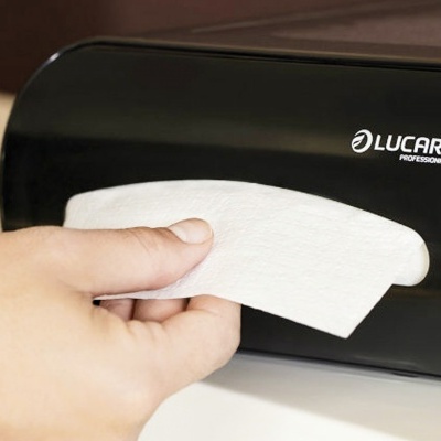 Dispenser preto de papel LUCART Professional com mão a retirar papel branco