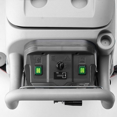 Painel de controlo com botões verdes e símbolos num equipamento cinzento