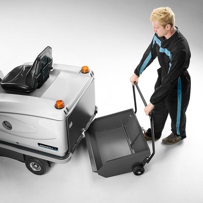 Homem mexendo num contentor de lixo cinzento ao lado de máquina de limpeza de piso cinzenta