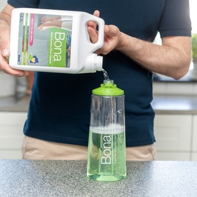 Produto de limpeza Bona com recipiente branco e garrafa translúcida verde numa cozinha