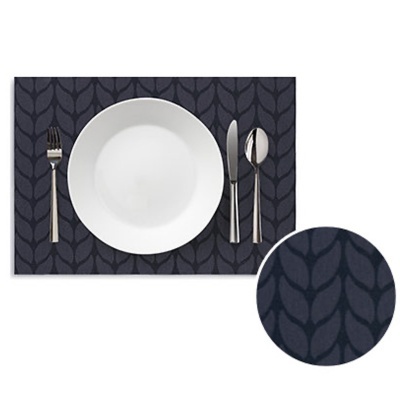 Conjunto de mesa com prato branco, talheres prateados e individual azul escuro com padrão de folhas