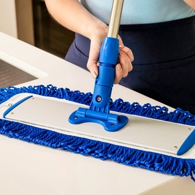 Mopa azul com microfibra sendo usada numa bancada branca