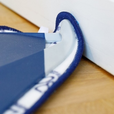 Protetor de porta em tecido branco com bordas azuis e base em madeira clara