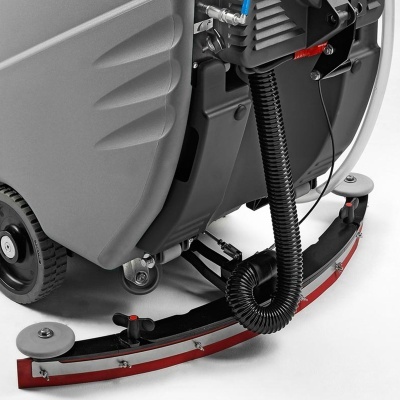 Parte inferior de equipamento de limpeza com rodas, mangueira e barra vermelha.