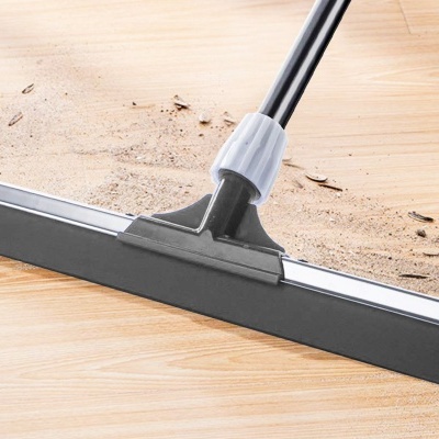 Rodo preto e cinza a limpar chão de madeira claro com poeira