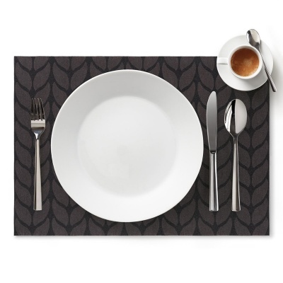 Conjunto de louça branca com talheres metálicos e café expresso em individual preto com padrão