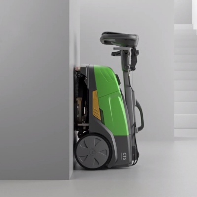 Máquina de limpeza compacta verde e preta junto a parede branca com escadas ao fundo