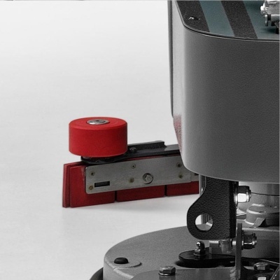 Parte de máquina com componentes metálicos, cilindro vermelho e base vermelha