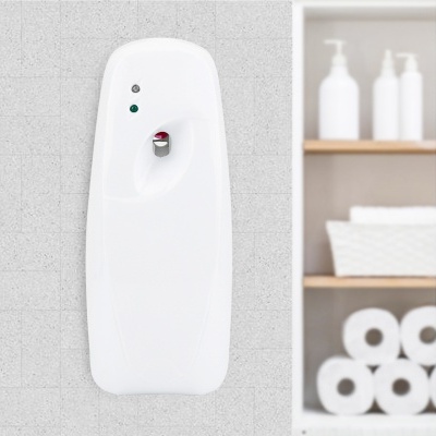 Dispenser automático branco montado na parede com prateleira com frascos e papel higiénico