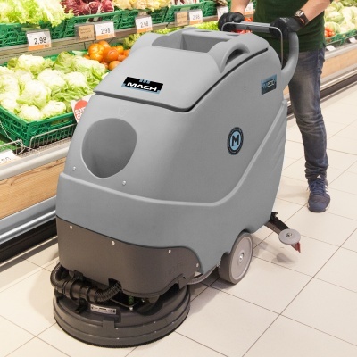 Máquina de limpeza industrial cinza em supermercado perto de frutas frescas