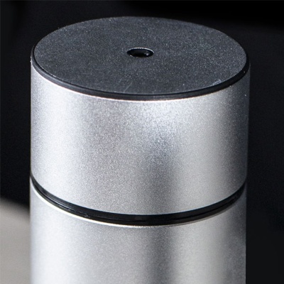 Parte superior de objeto cilíndrico metálico prateado com tampa preta