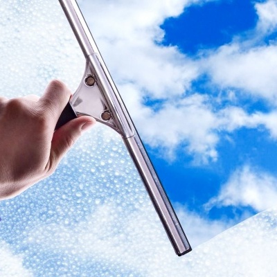 Limpa-vidros metálico a limpar vidro com espuma de sabão