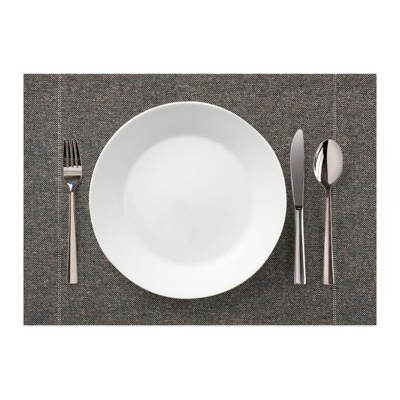 Conjunto de prato branco e talheres de metal sobre individual cinzento