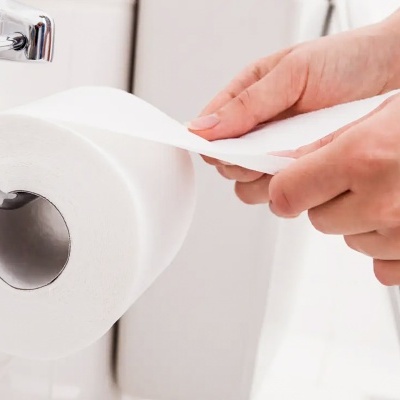 Rolo de papel higiénico branco num suporte metálico cromado numa casa de banho