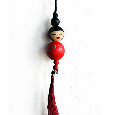 Pingente decorativo de contas de madeira com rosto pintado e tassel vermelho