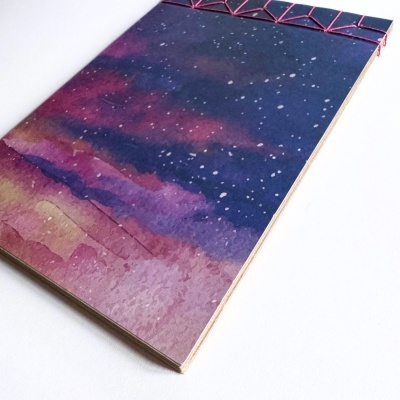 Caderno com capa de céu estrelado e encadernação artesanal rosa