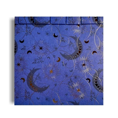 Caixa azul decorada com padrões de luas e estrelas douradas