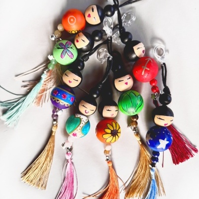Chaveiros coloridos com bonecas de madeira e franjas