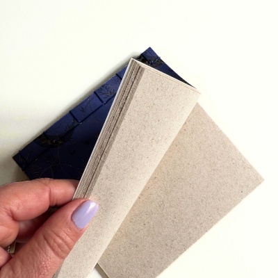 Bloco de papel reciclado bege com capa azul escura decorada