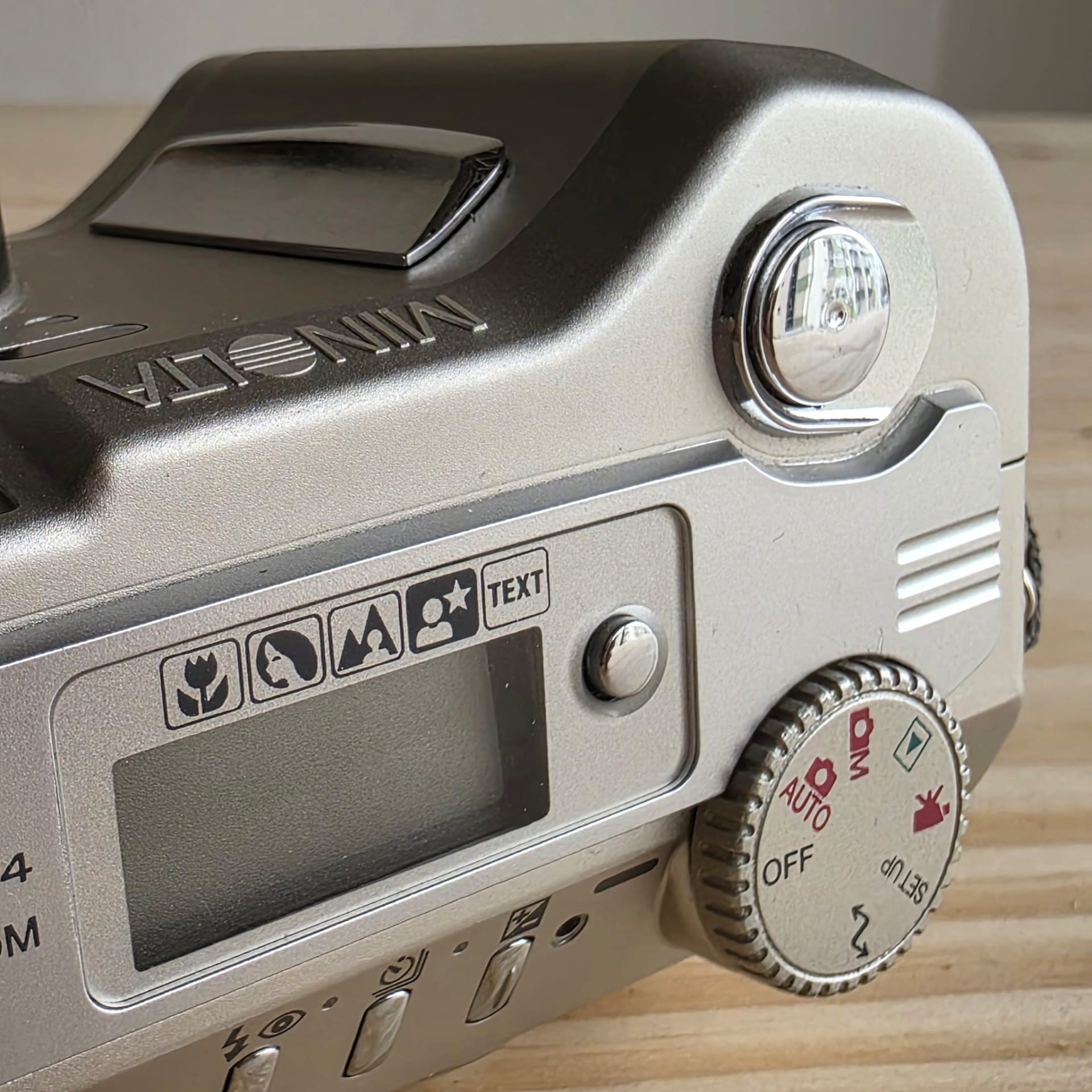 Minolta S304 3,3. Detalhe de máquina fotográfica prata Minolta com botões e visor digital