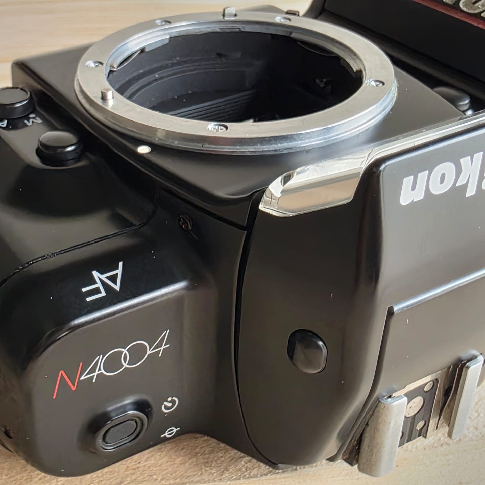 Nikon F4004 Câmara fotográfica Nikon N4004 preta com encaixe para objectiva e botão de disparo