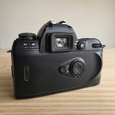 Câmara fotográfica preta retro vista traseira sobre superfície de madeira clara