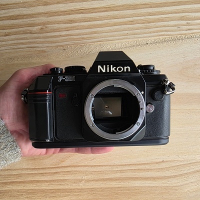 Câmera fotográfica analógica Nikon F-301 preta sem lente.