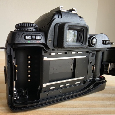 Câmara fotográfica analógica preta aberta mostrando interior