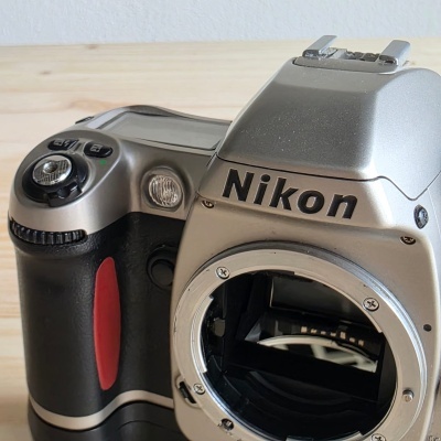 Câmara fotográfica Nikon prateada e preta sem lente