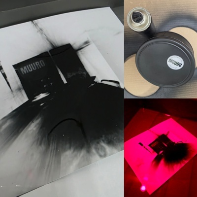 Stencil MUURO preto e branco, lata de spray preta e objeto cilindríco preto com etiqueta MUURO