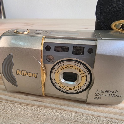 Máquina fotográfica clássica Nikon cinza metálico com detalhes dourados