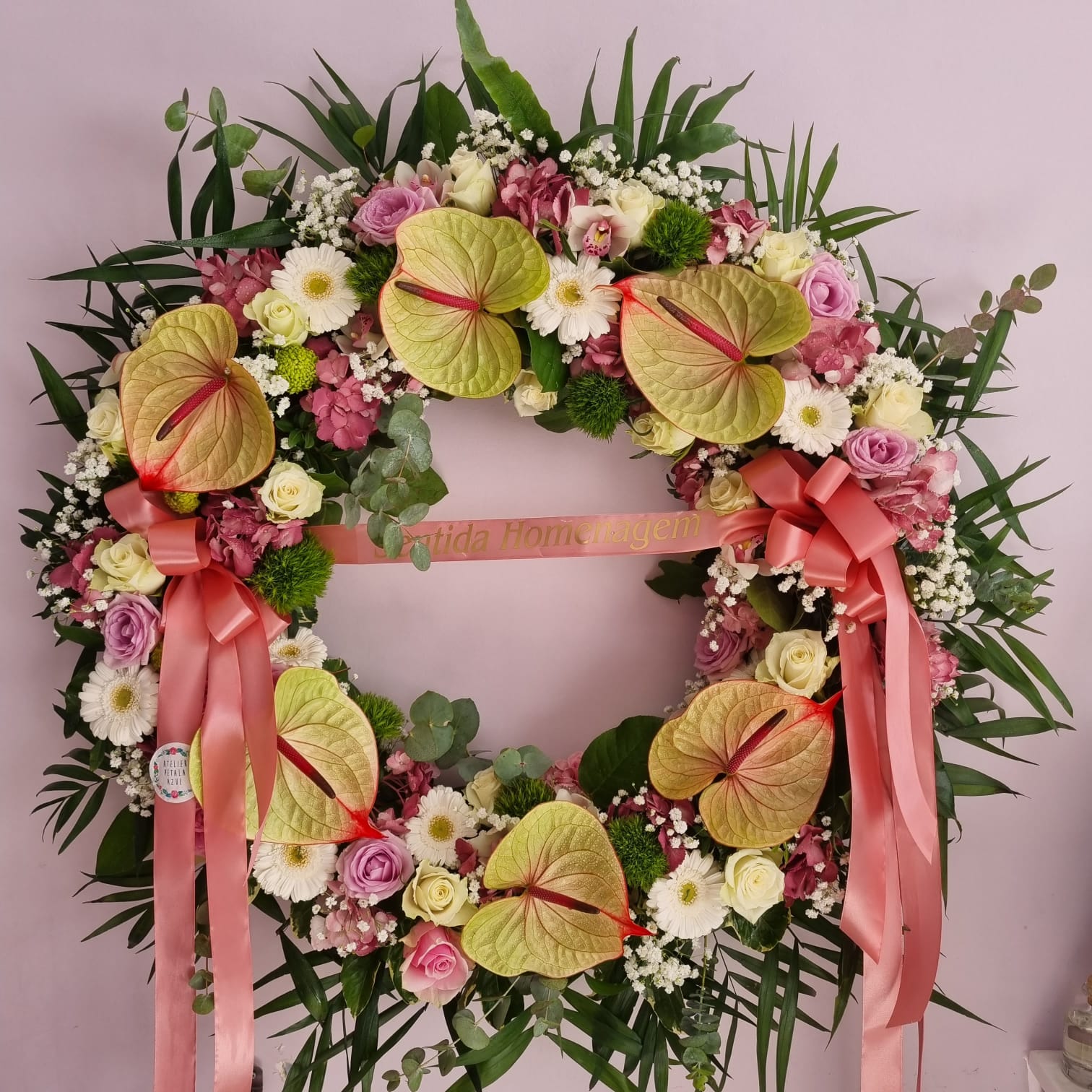 coroa fúnebre colorida com flores e fita rosa