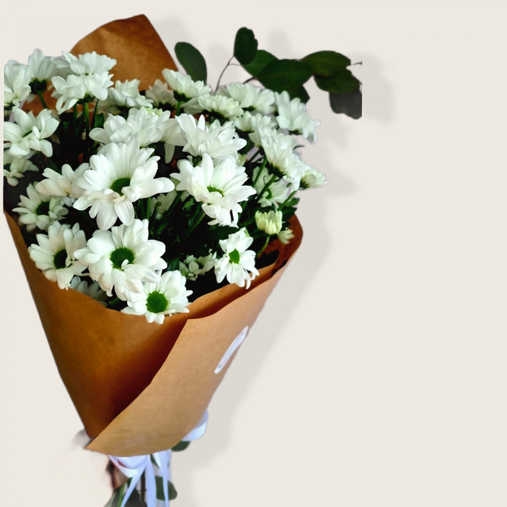 Ramo de flores brancas em papel castanho com fita branca