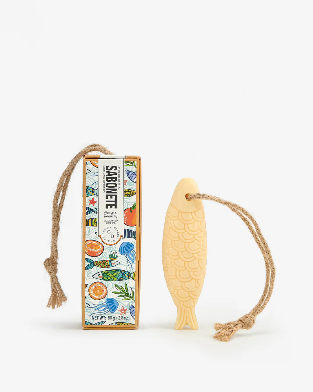 Sabonete perfumado em formato de peixe com cordão, ao lado da sua caixa decorada colorida.