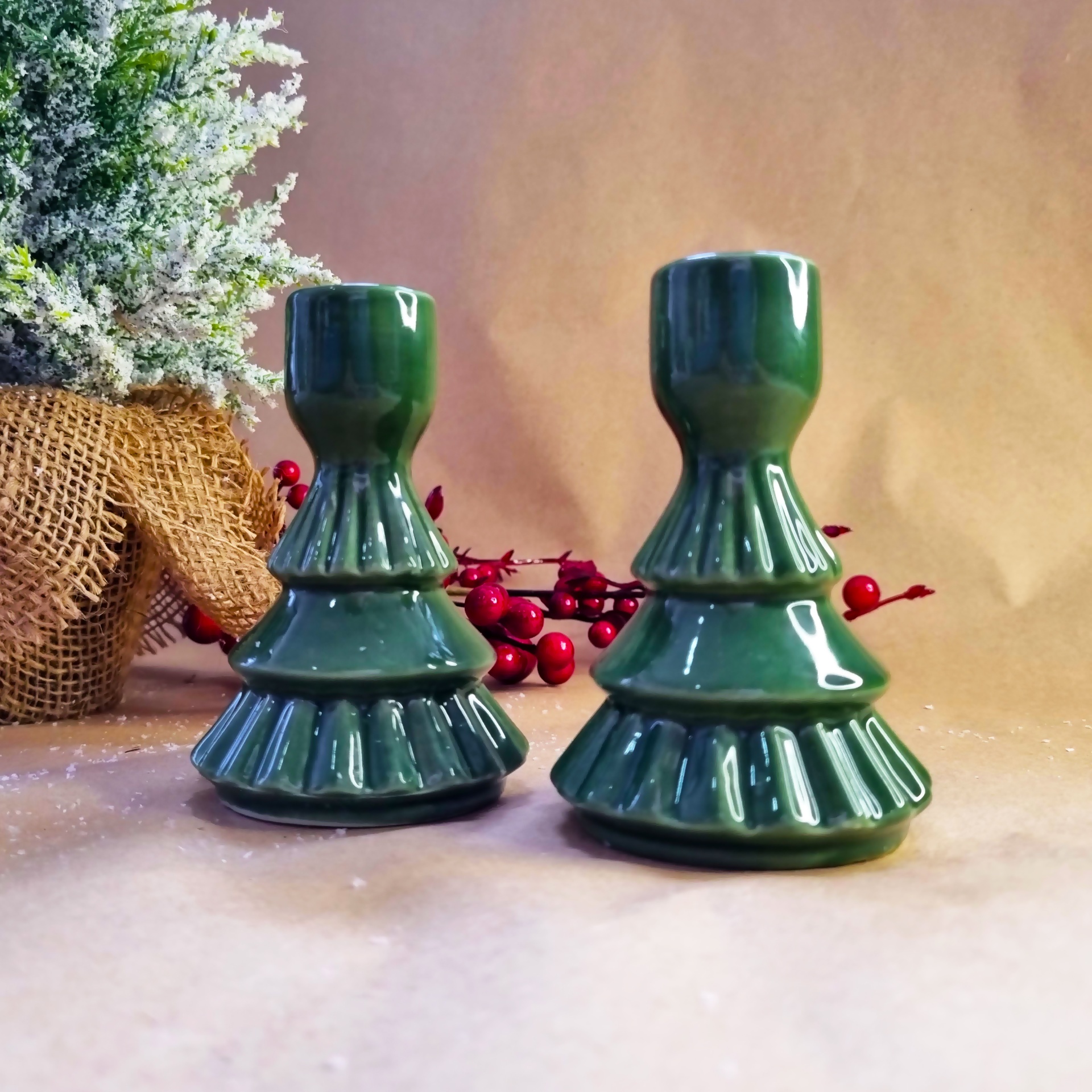Dois castiçais verdes cerâmicos com design em camadas, estilo árvore de Natal.