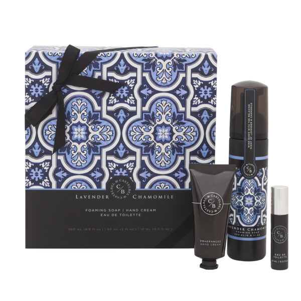 Conjunto de produtos de banho com embalagem decorativa azul, branca e preta, incluindo sabão, creme de mãos e eau de toilette.