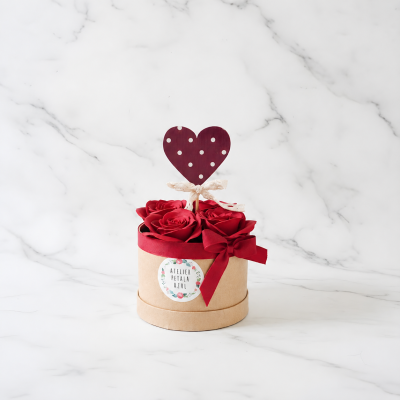 Arranjo floral com rosas vermelhas em vaso redondo decorado
