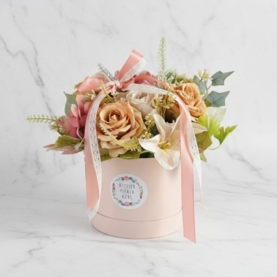 Arranjo floral decorativo com flores artificiais em caixa rosa