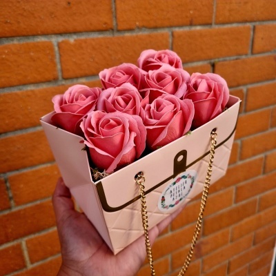 Caixa tipo bolsa rosa com flores rosas e correntes douradas