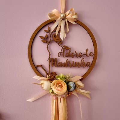 Decoração pendente redonda de madeira com flores e texto 'Adoro-te Madrinha'