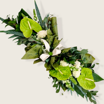 Arranjo floral com folhas verdes, flores anthurium verdes e flores brancas com fita branca