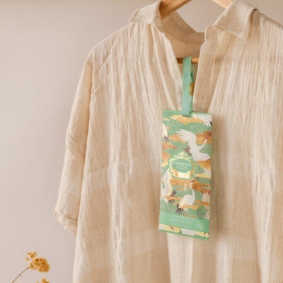 Camisa bege pendurada com etiqueta verde ilustrada