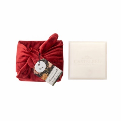 Conjunto com tecido vermelho macio e caixa branca com texto da marca Castelbel Portugal