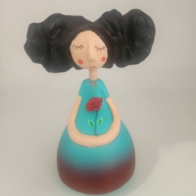 Escultura de rapariga com vestido azul e cabelo preto volumoso