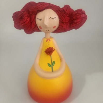 Figura decorativa de boneca com vestido amarelo e cabelo vermelho